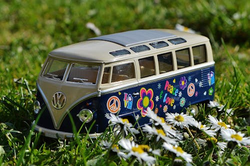 Free Volkswagen Beige and Blue Van Scale Model Near White Daisy Flower during Daytime Stock Photo