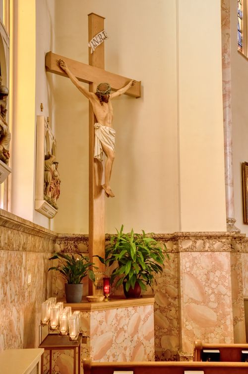Free Elegant depiction of a crucifix in a serene church setting with candles and marble accents. Stock Photo