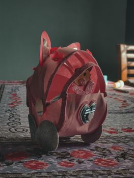 A pink decorative item on a floral-patterned table indoors, showcasing creativity and design.