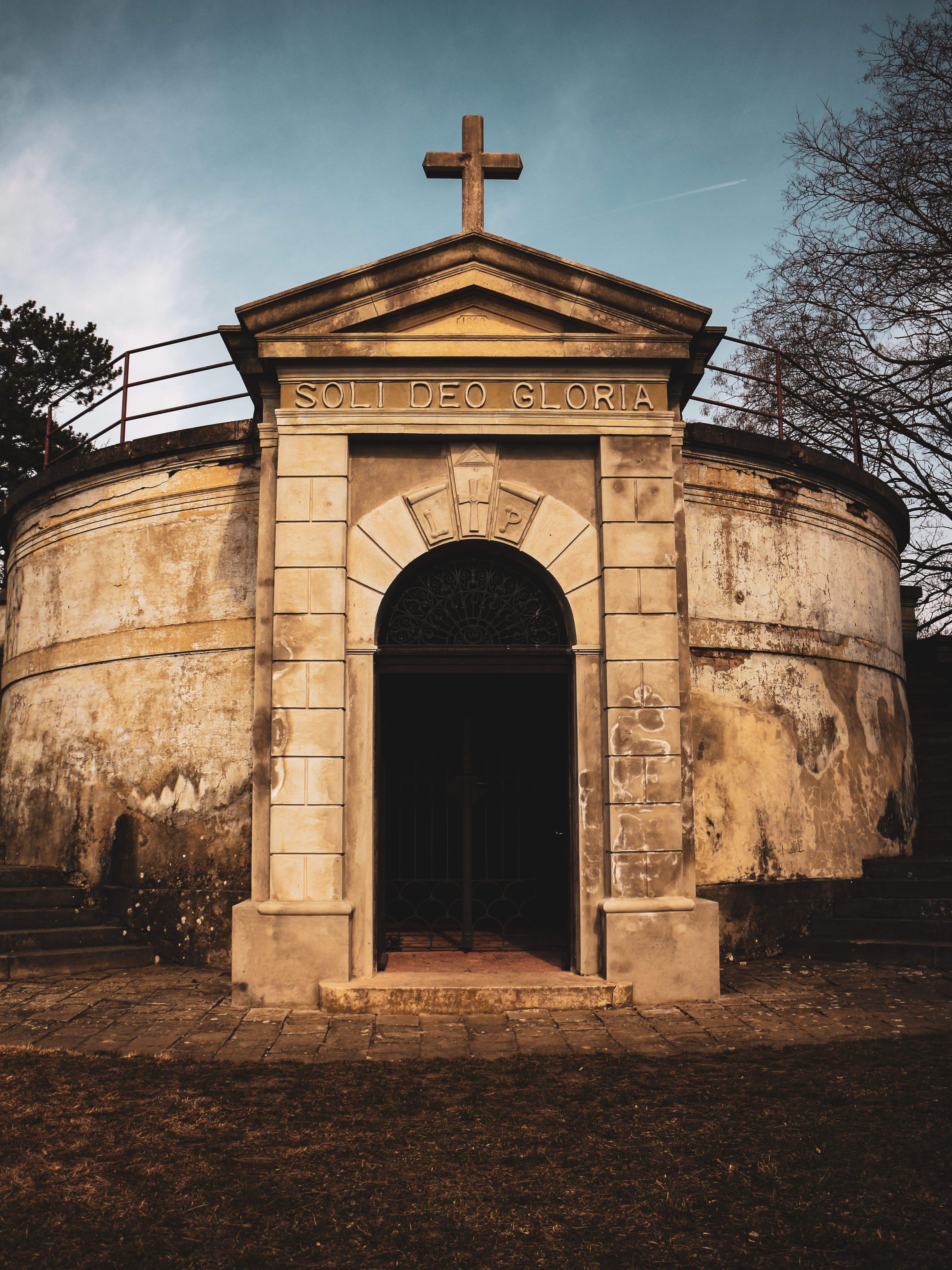 Rustic chapel facade in Szob, Hungary, with 'Soli Deo Gloria' inscription under a cross.