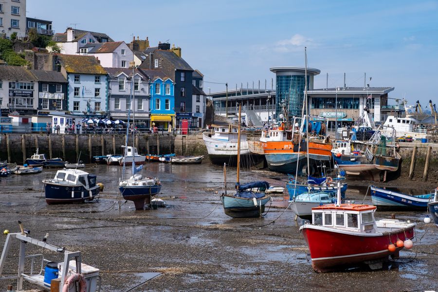 Fishing boats moored in Brixham harbour at low tide in Devon