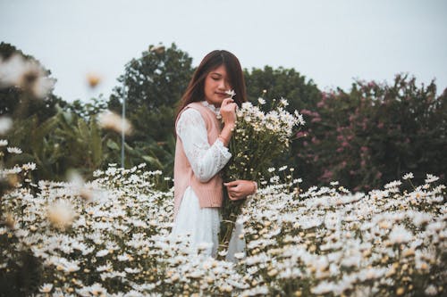 Beyaz Taç Yapraklı çiçeklerle çevrili Kadın