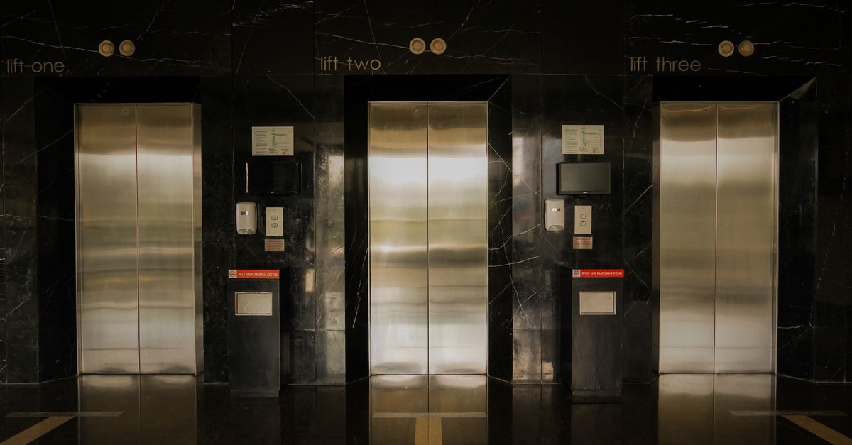 Sleek elevator lobby with stainless steel doors, reflecting modern architecture.