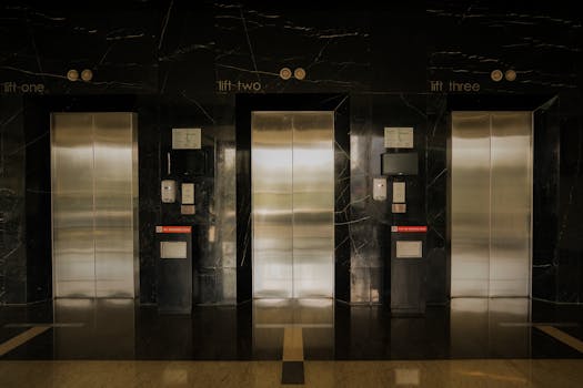 Sleek elevator lobby with stainless steel doors, reflecting modern architecture.