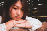 一位富有洞察力的年轻女子将下巴靠在树枝上，陷入沉思