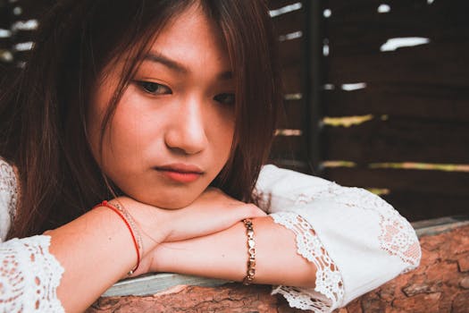 一位富有洞察力的年轻女子将下巴靠在树枝上，陷入沉思