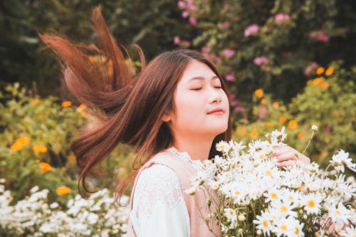 デイジーの花束を運ぶ女性