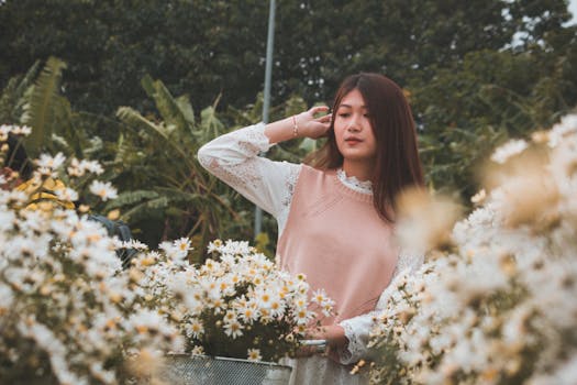 这幅宁静的肖像描绘了一位年轻女子站在花园里，周围是郁郁葱葱的白花