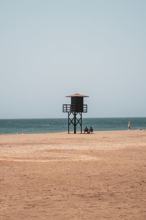 A lifeguard tower on the beach with the ocean in the background