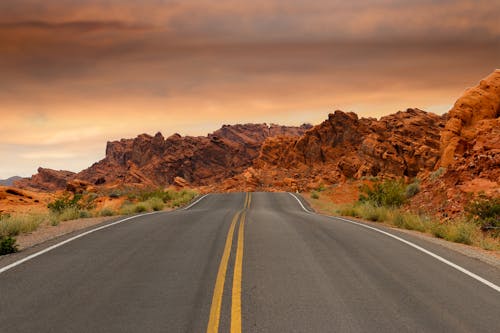Free Gray Concrete Road Beside Brown Mountain during Golden Hour Stock Photo