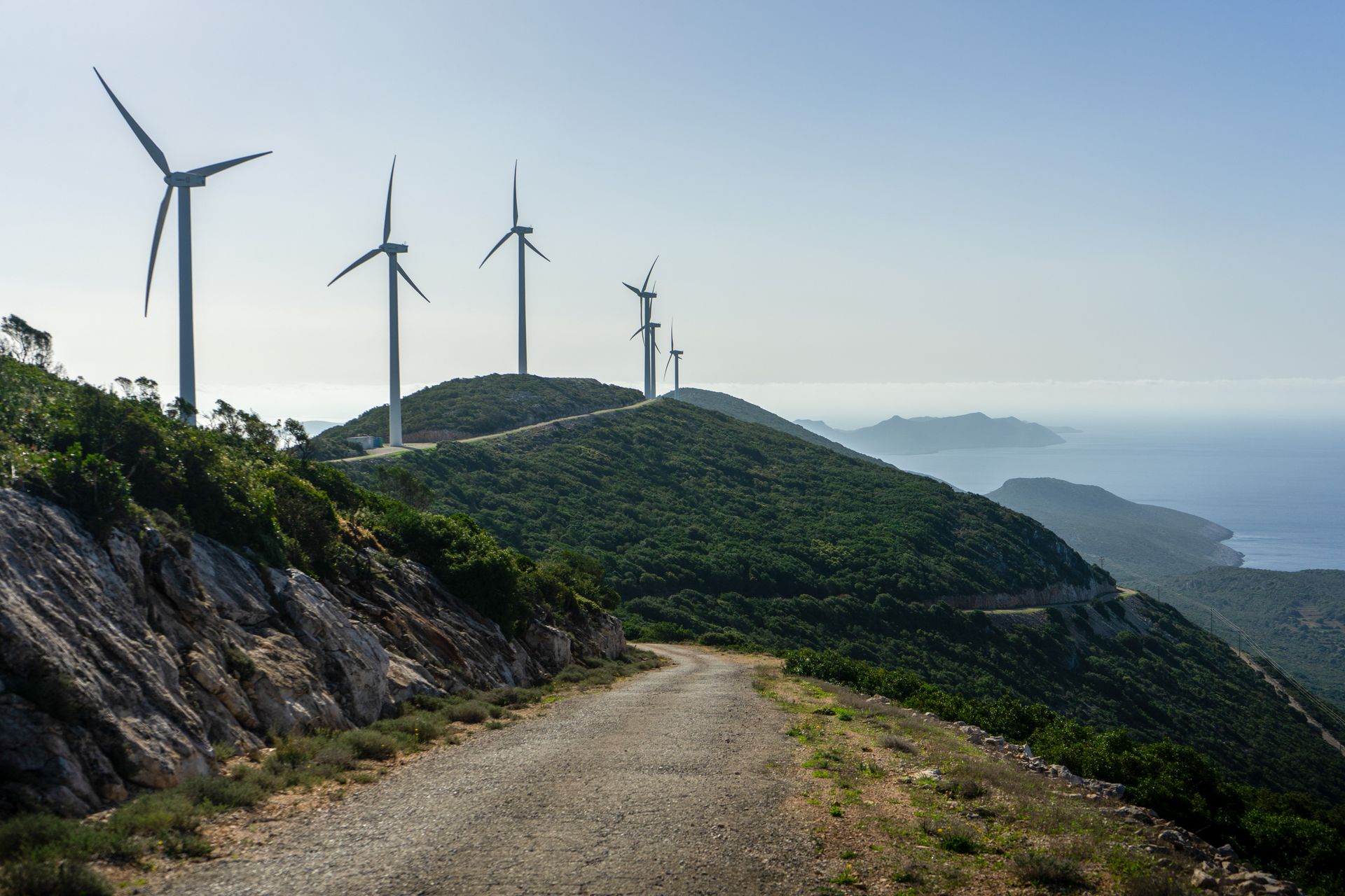 Dirt Road by Wind Turbines on Hill