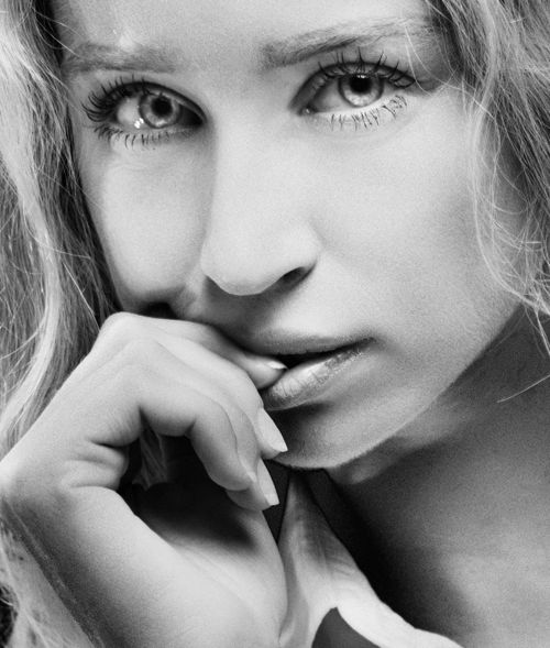 Free Close-up black and white portrait of a woman with hand on chin, expressing contemplation. Stock Photo