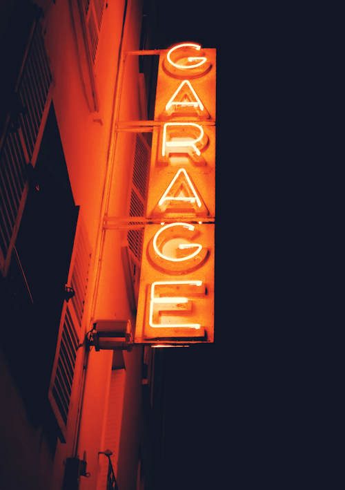 Orange Neon Sign on the Side of a Building in City