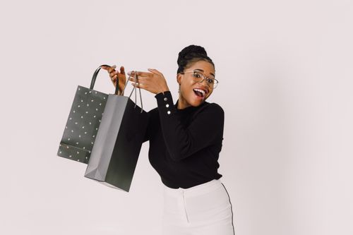 Free Happy woman holding shopping bags with joy on a white background. Stock Photo