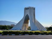 A stunning view of the Azadi Tower in Tehran, Iran, showcasing its unique architecture against a clear blue sky.