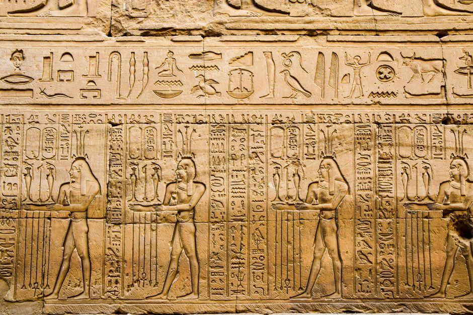 Detailed hieroglyphics and carvings on a wall in Luxor, Egypt, showcasing ancient history.