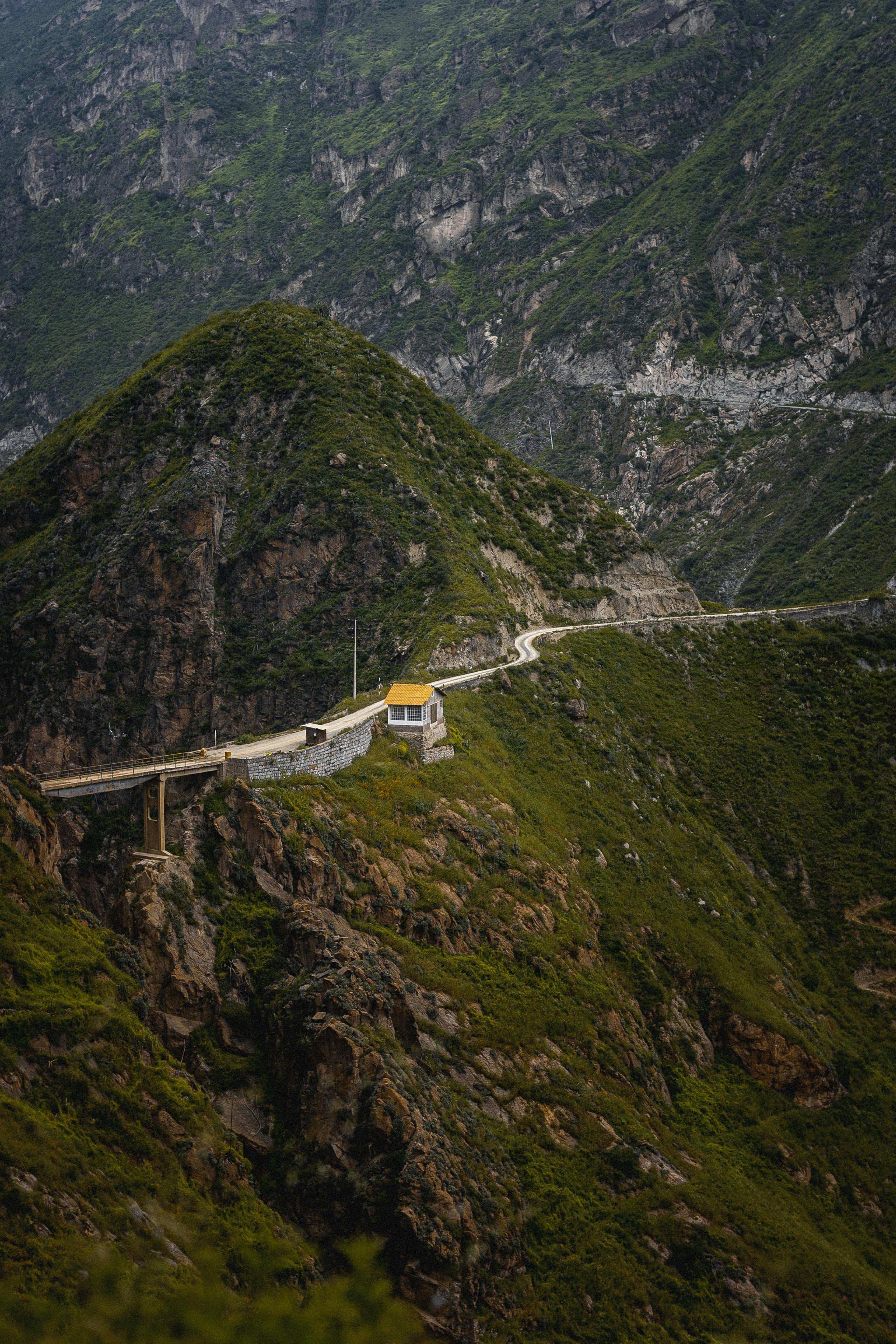 A scenic winding road through green mountain terrain in San Pedro de Casta, Peru.