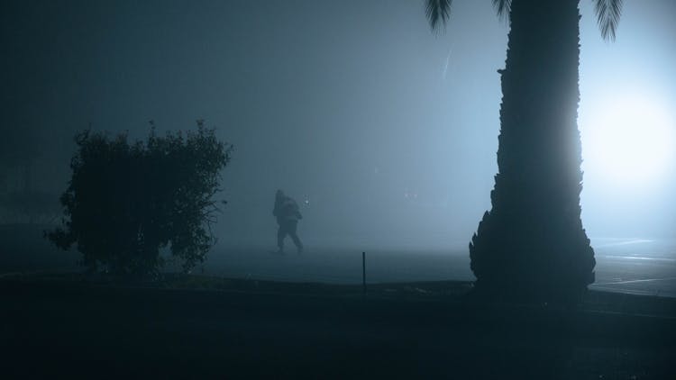 Man Walking On Illuminated Beach At Night