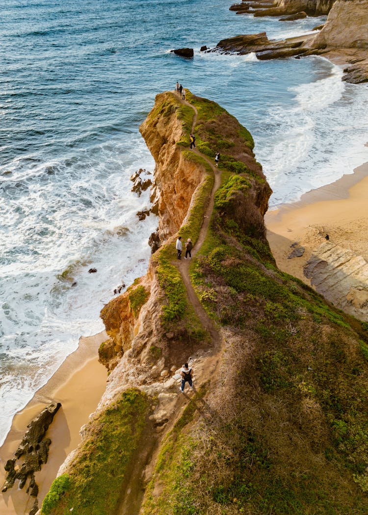 People Walking On Rock At Sea