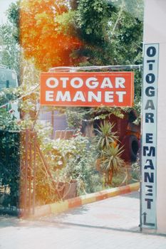 Entrance to a Turkish bus station with vibrant signage and greenery.