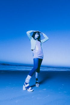 Stylish young woman posing on Daytona Beach, Florida, in chic outfit and high heels.