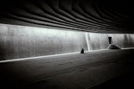 一个孤独的人正在一座引人注目的巨大现代极简主义大厅里冥想