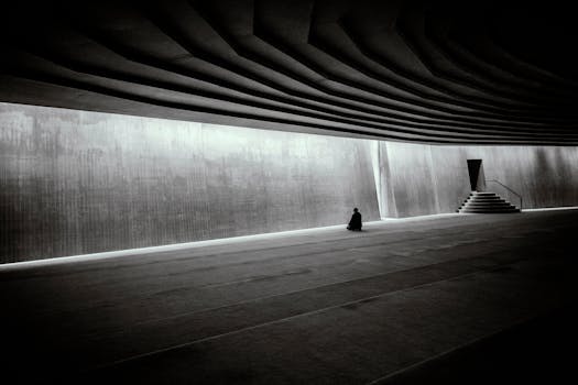 一个孤独的人正在一座引人注目的巨大现代极简主义大厅里冥想