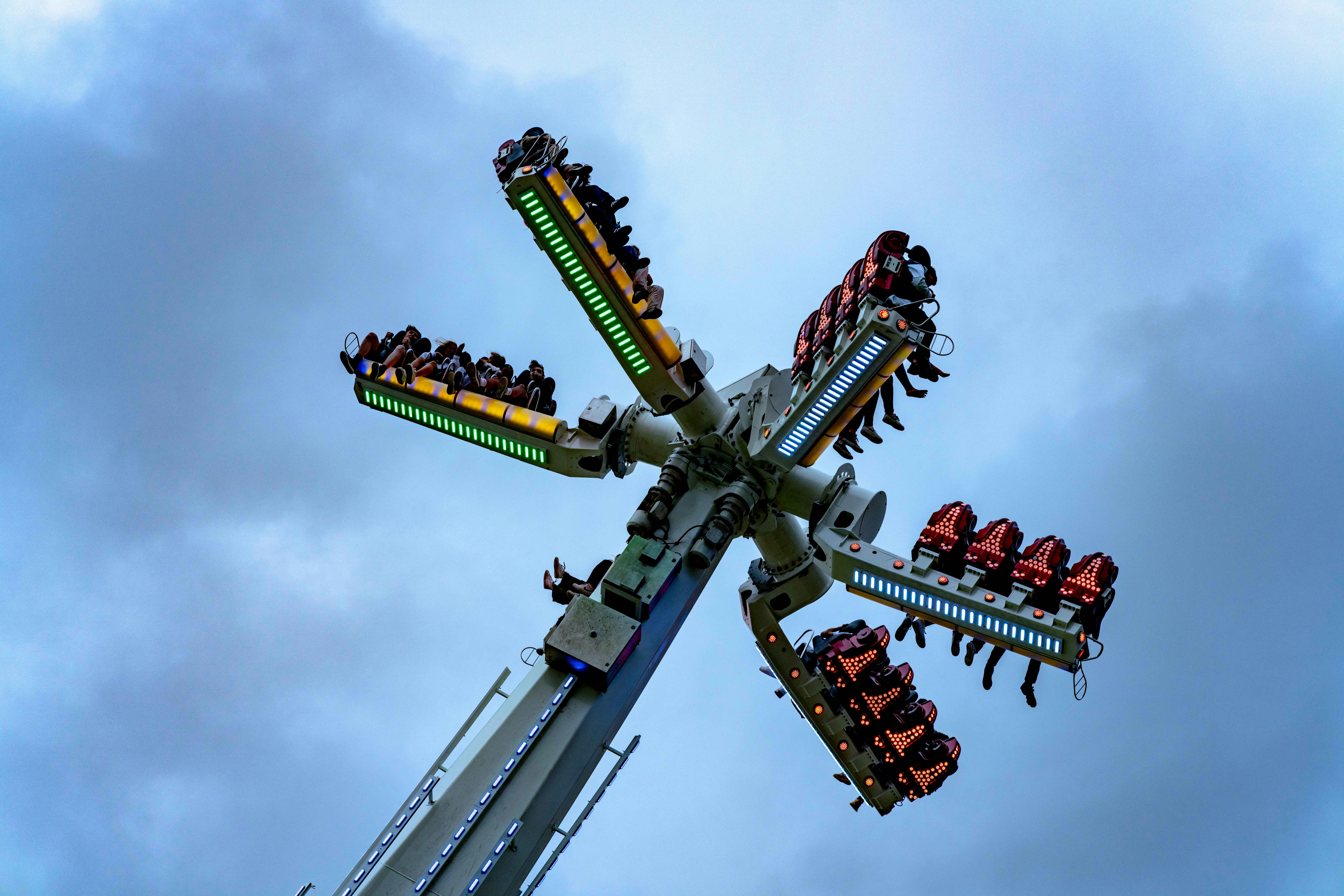 Dramatic shot of a spinning amusement park ride with people enjoying a thrilling experience.