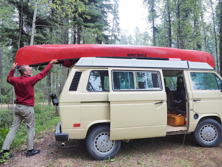 Man Putting Canoe On Van Roof