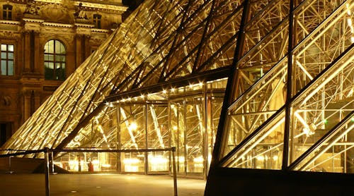 無料 夜間に黄色のライトが付いている博物館の外の金属フレームガラスピラミッド 写真素材