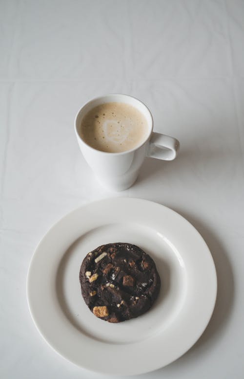 Mug of Cappuccino and a Chocolate Cookie on a Plate
