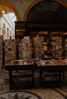 Vintage bookstore in Paris with books and postcards in a historic arcade setting.