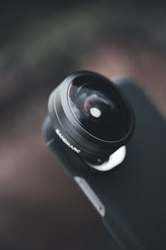 Detailed close-up of a fisheye lens attachment on a smartphone, showcasing optics technology.