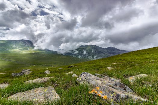 令人惊叹的山地景观，与戏剧性的云、岩石和绿草相映成趣