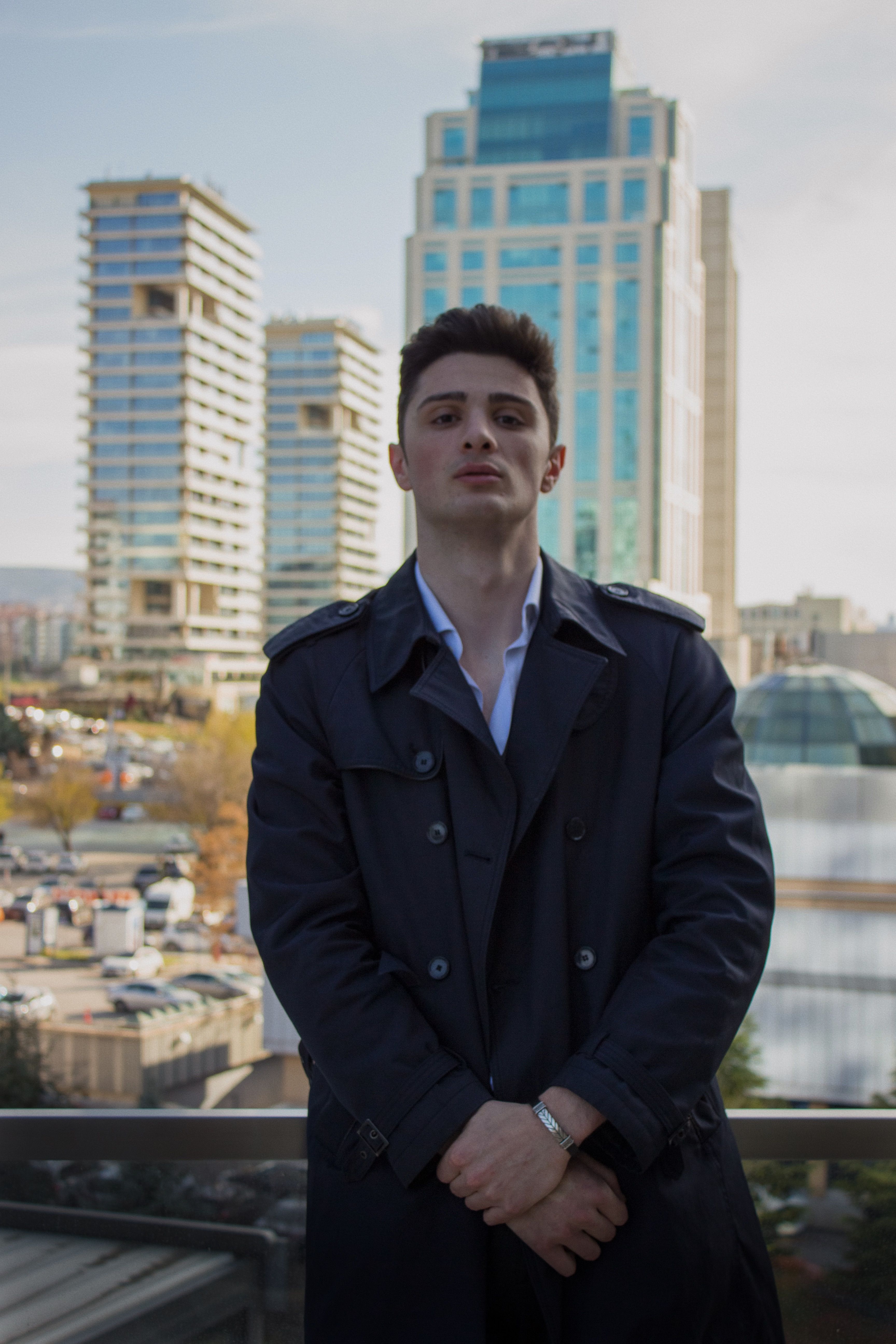 Portrait of a confident man in Ankara with city skyscrapers in the background.