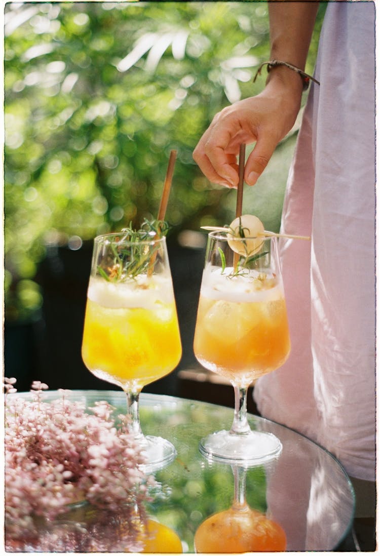 Woman Standing Near Cocktails In Glasses In Garden