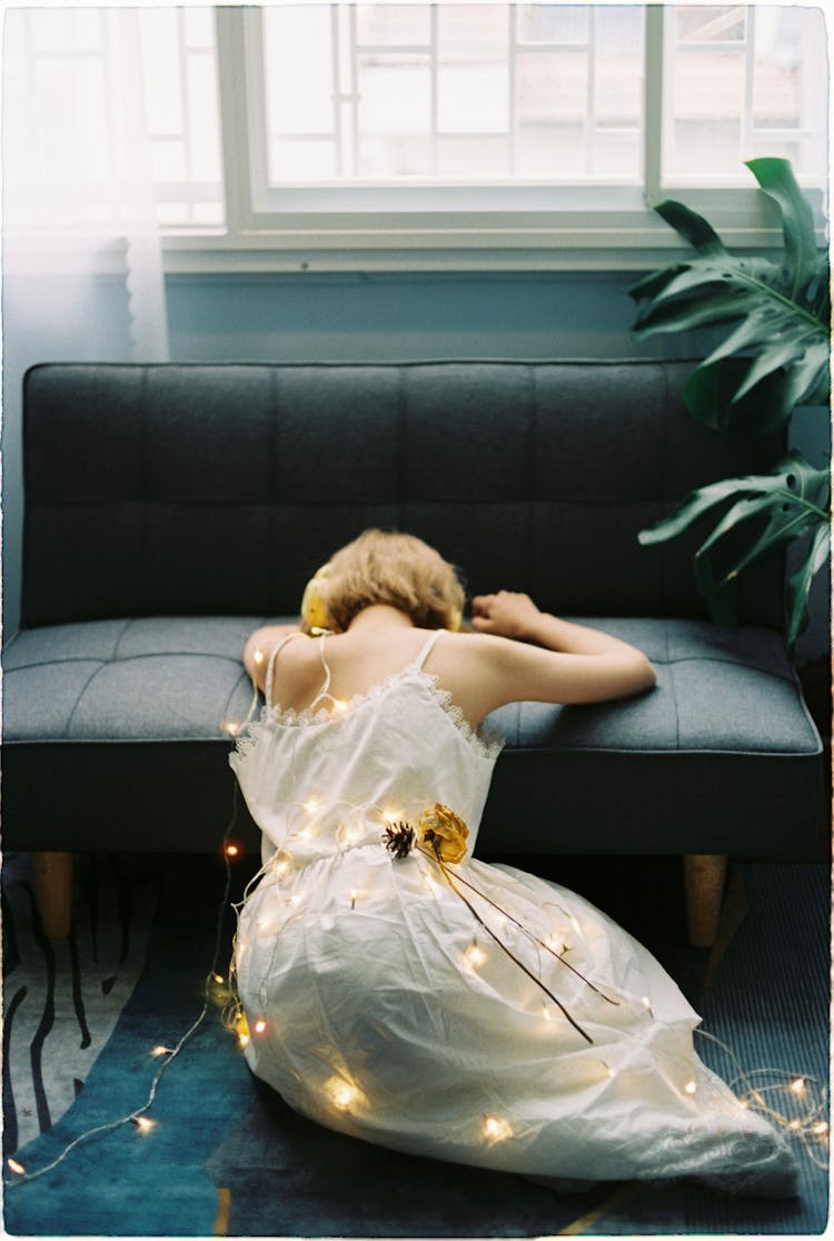 Woman In Dress And Lights Sitting On Home Floor