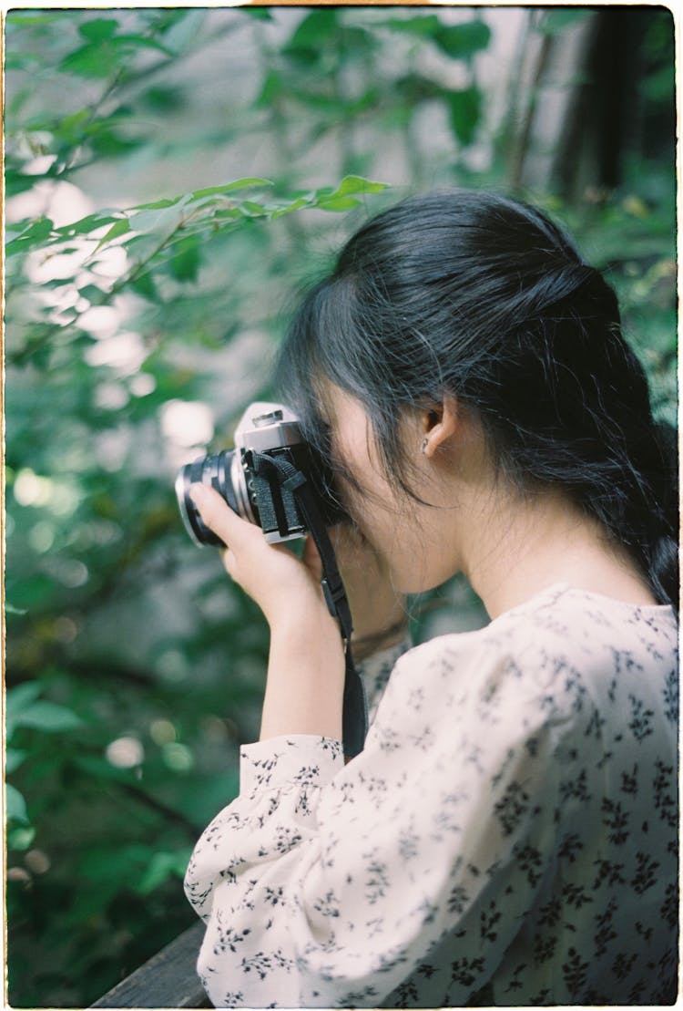 Woman Taking Picture With Retro Camera In Nature