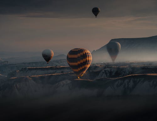 Hot Air Balloons Rising Above the Rocks on a Foggy Morning
