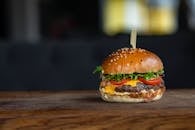 木制表面上的芝士汉堡搭配新鲜食材，令人垂涎欲滴，非常适合美食爱好者