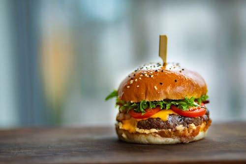 Free Photo of Juicy Burger on Wooden Surface Stock Photo