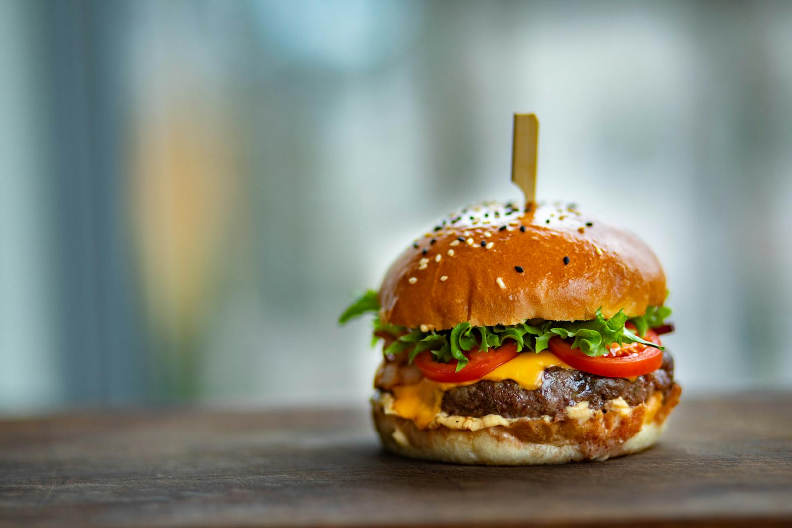 Fresh, seasonal produce surrounding a homemade hamburger to highlight the benefits of buying ingredients in season.