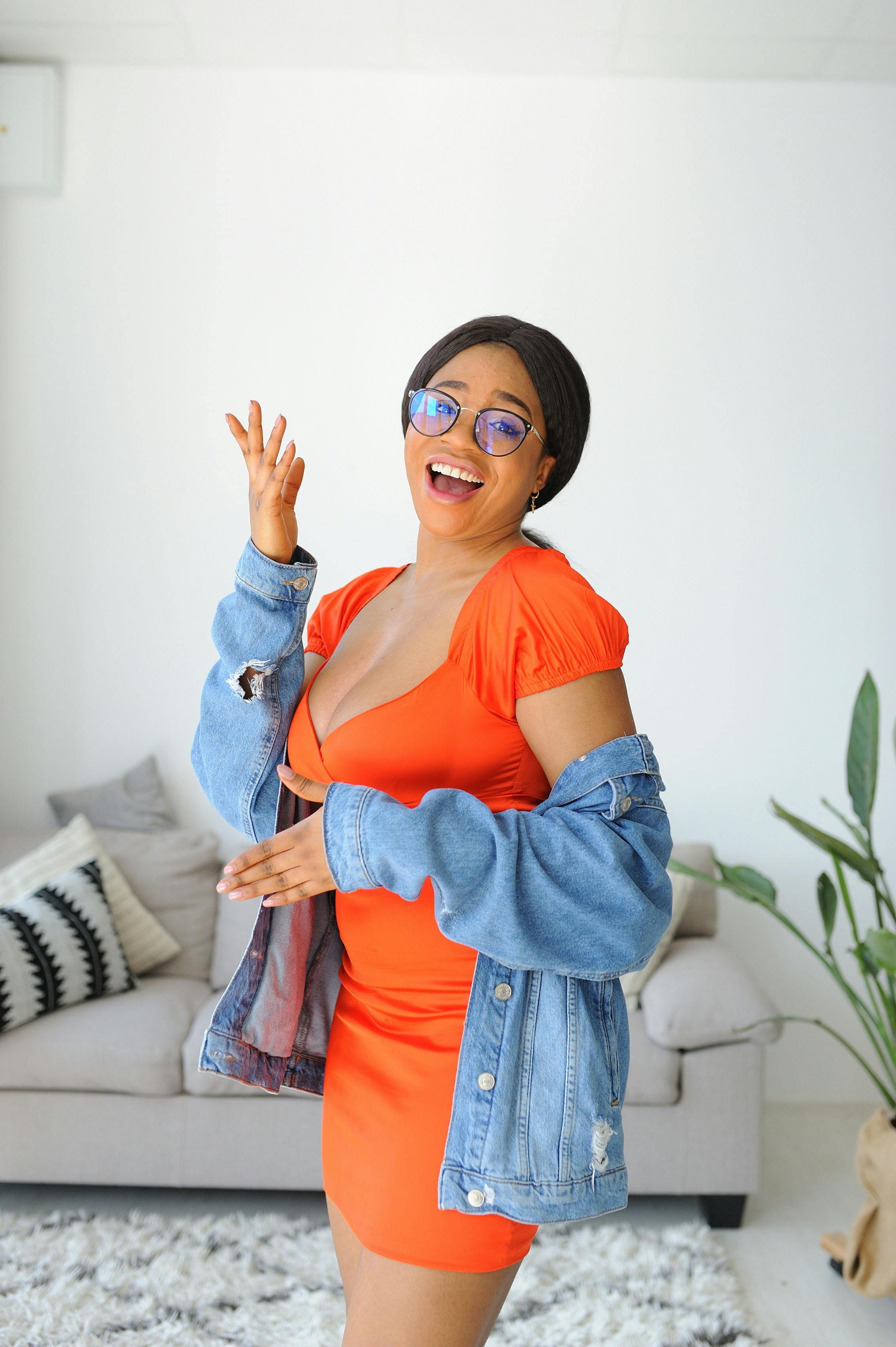 Young Woman Wearing an Orange Dress and a Denim Jacket Free Stock Photo