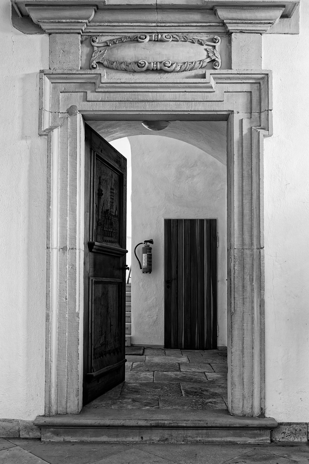 Sophisticated black and white photo showcasing an architectural doorway with intricate carvings.