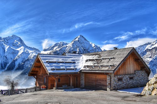 A Wooden House in Rocky Snowcapped Mountains 
