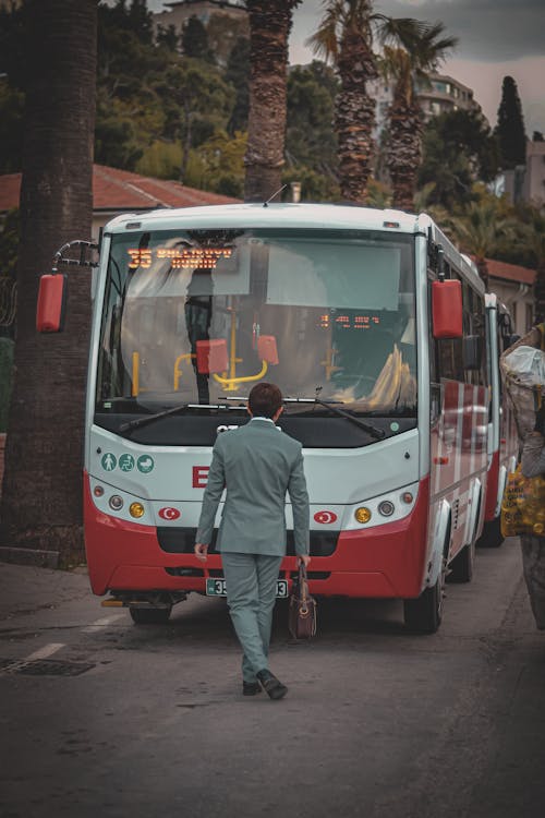 A Man in a Suit in Front of a Bus