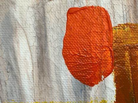 Close-up of textured abstract art with red and orange paint on cracked canvas.