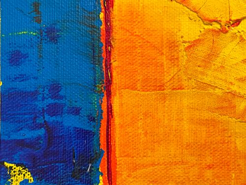 Free Close-up of a textured abstract painting with bold blue and yellow hues. Stock Photo
