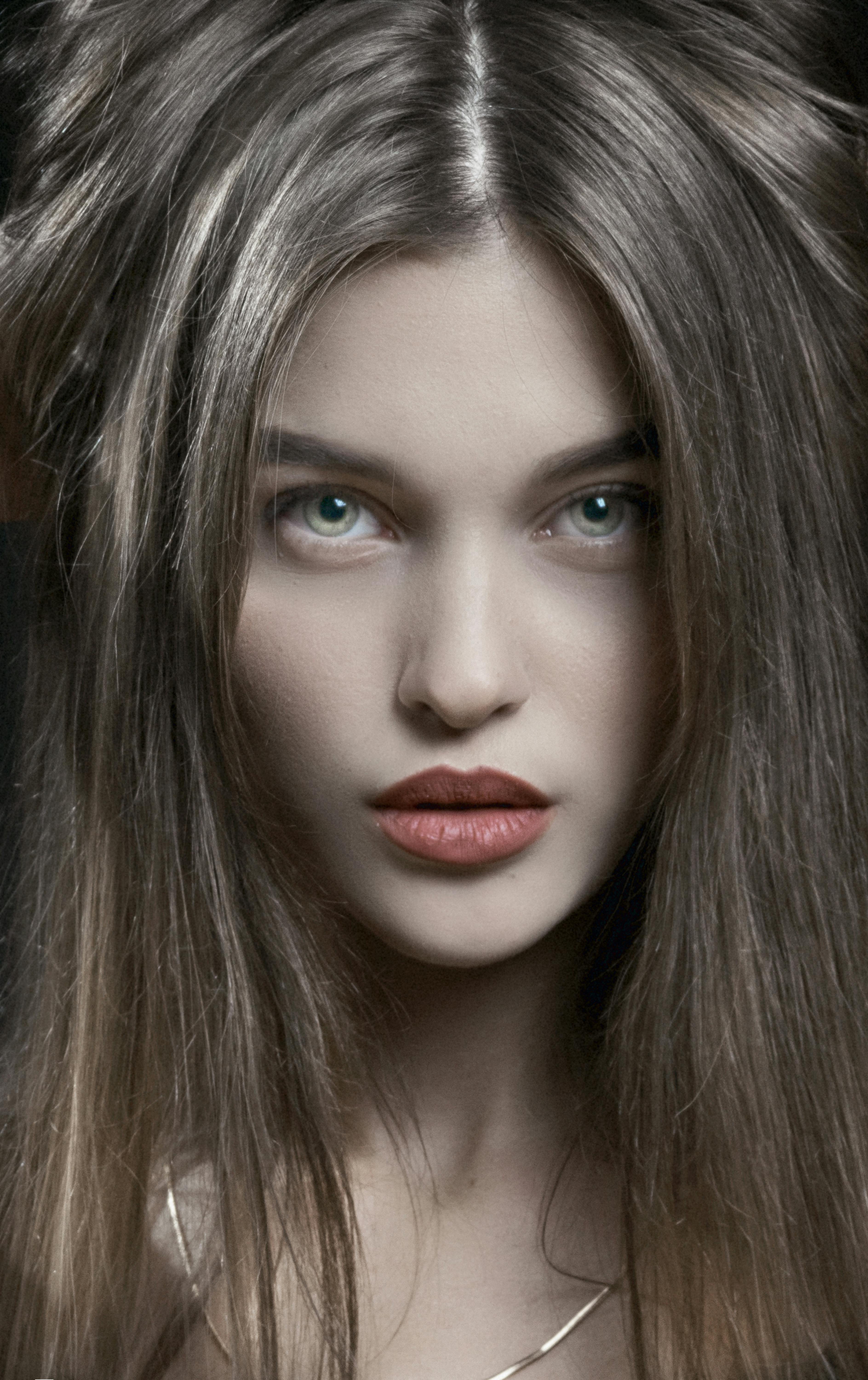 Close-up portrait showcasing a woman's striking features and long hair.