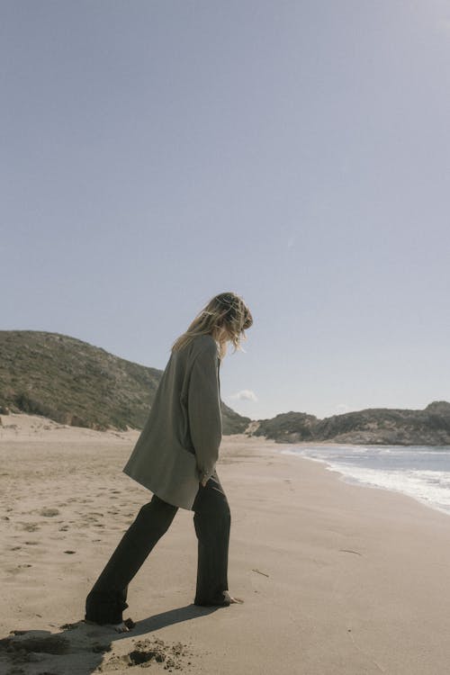 Woman in Suit Walking on Sand Beach